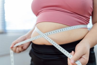 Ce este balonul gastric Allurion și de ce este diferit de alte metode de slăbit? femeie cu obezitate isi masoara circumferinta abdominala